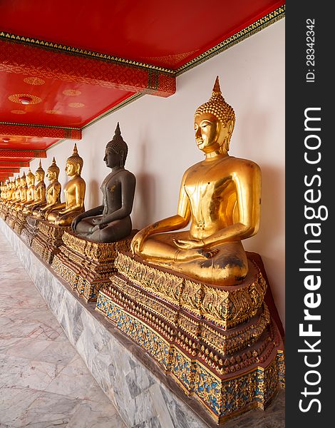 Buddha statues made of gold and black brass is line in a row temples in thailand