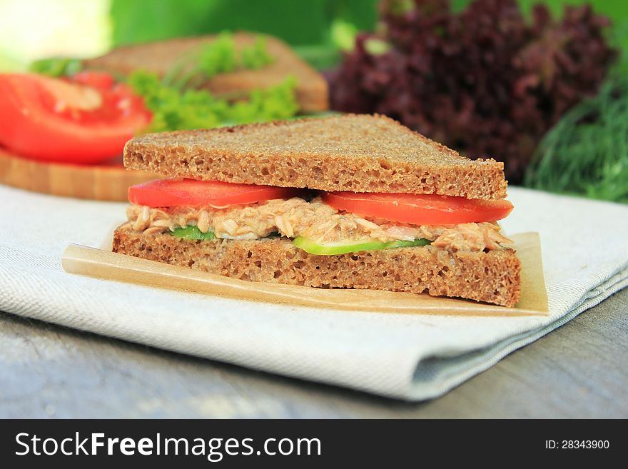 Rye bread sandwich with tuna, cucumber slices and tomatoes for picnic