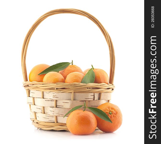 Tangerines with leaves in a basket on a white background