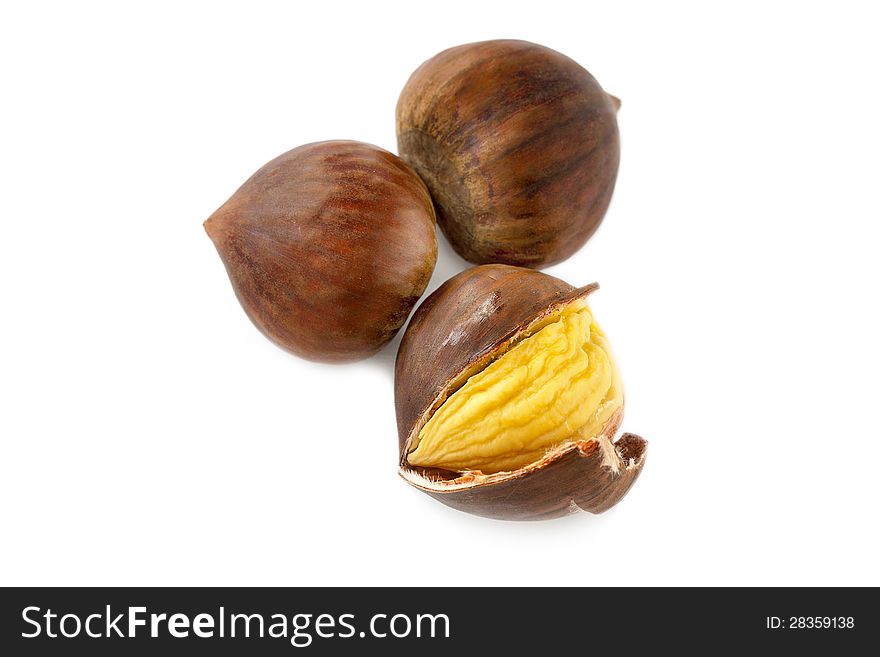 Fresh whole autumn chestnuts with one having its shell split and peeled back to expose the kernel on a white background