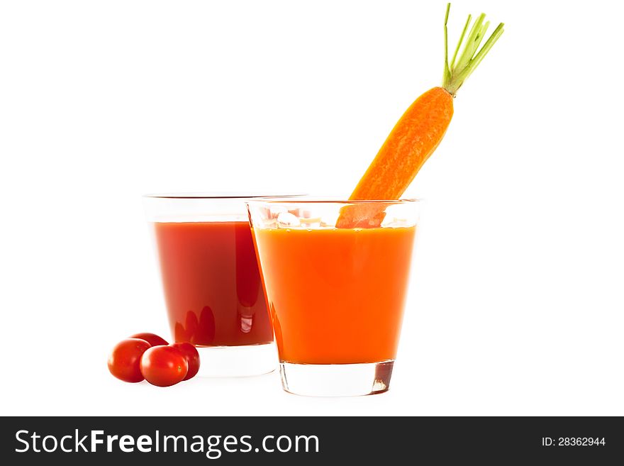 Two glasses of healthy freshly blended tomato and carrot juice accompanied by whole ripe tomatoes and a carrot isolated on white