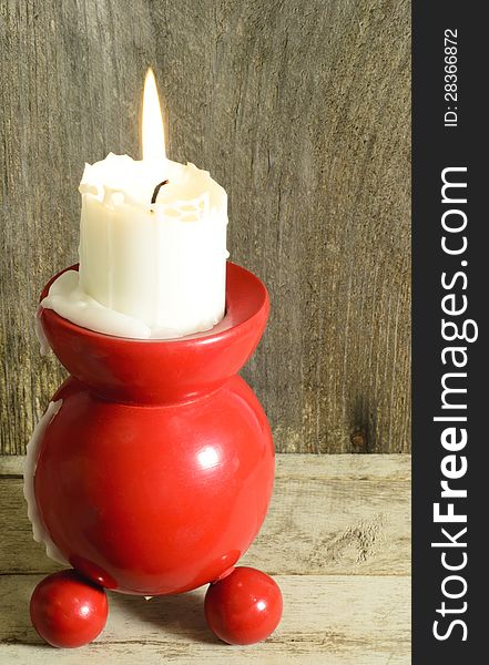 Red and round traditional candle holder with burning candle. Red and round traditional candle holder with burning candle