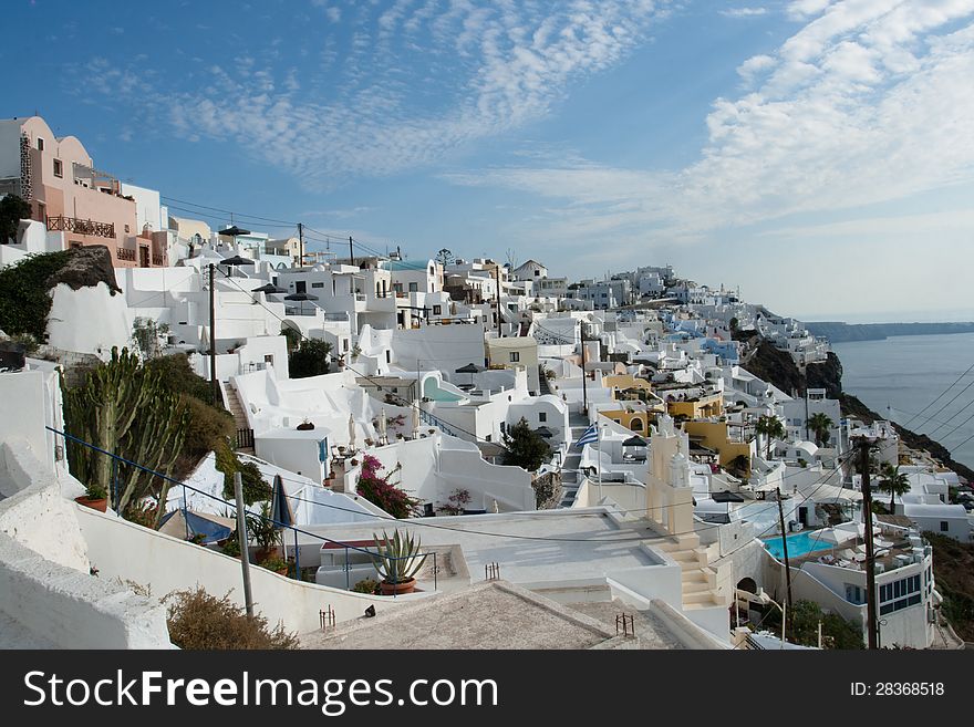 Nice white houses with swimming-pools on the cliff of the island Santorini. Greece