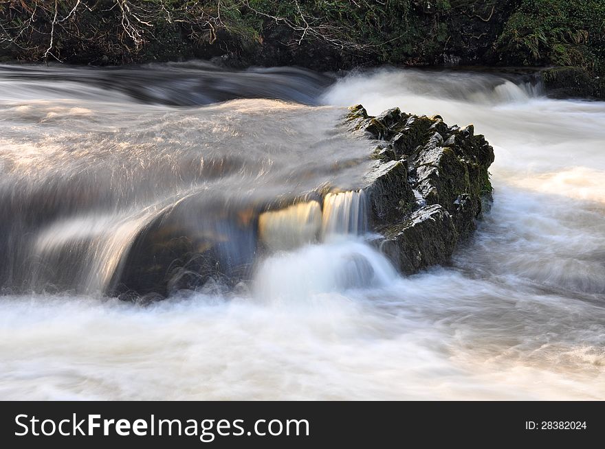 Swollen river with swirling water over rocks. Swollen river with swirling water over rocks