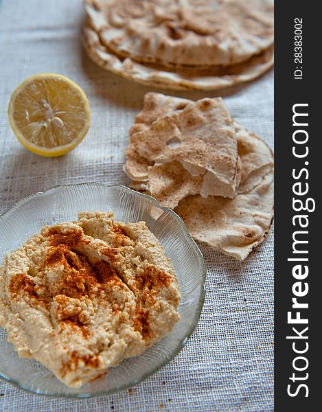 Dish of hummus with pita bread and paprika