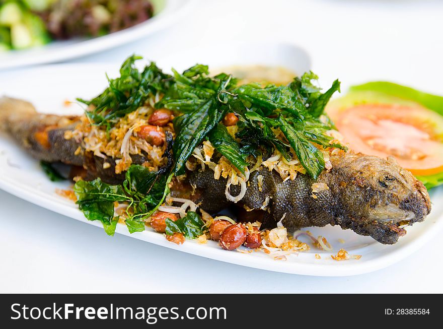 Fried fish and mint leaves  on white plate