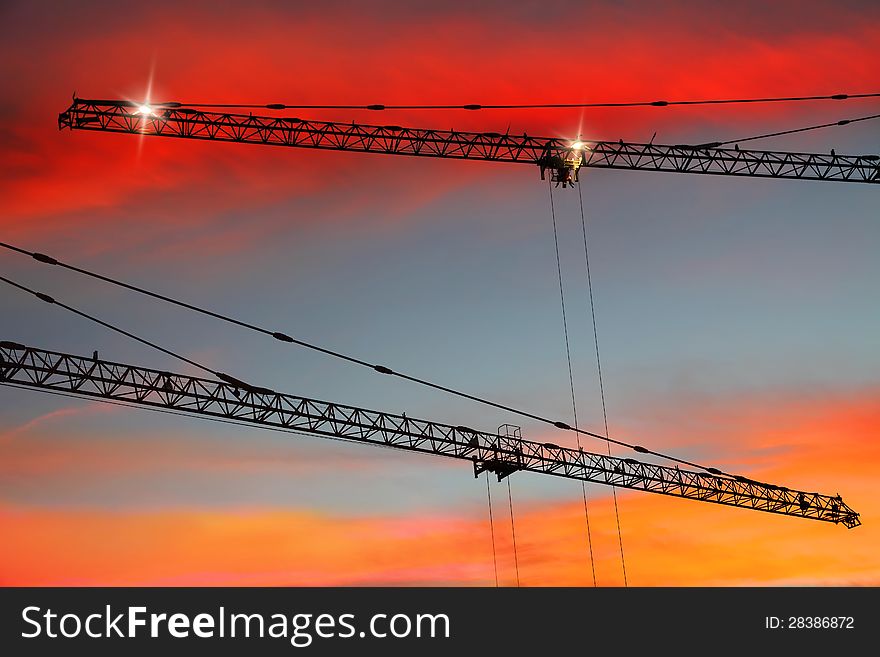 Construction cranes on sunset bright background. Construction cranes on sunset bright background