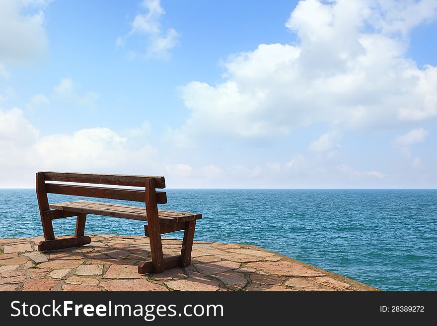 Wooden bench on open space overlooking a beautiful sunny sea view. Wooden bench on open space overlooking a beautiful sunny sea view