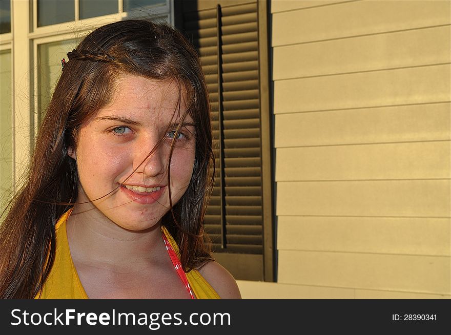 A young American teen is smiling during a sunrise in Cape Cod. A young American teen is smiling during a sunrise in Cape Cod