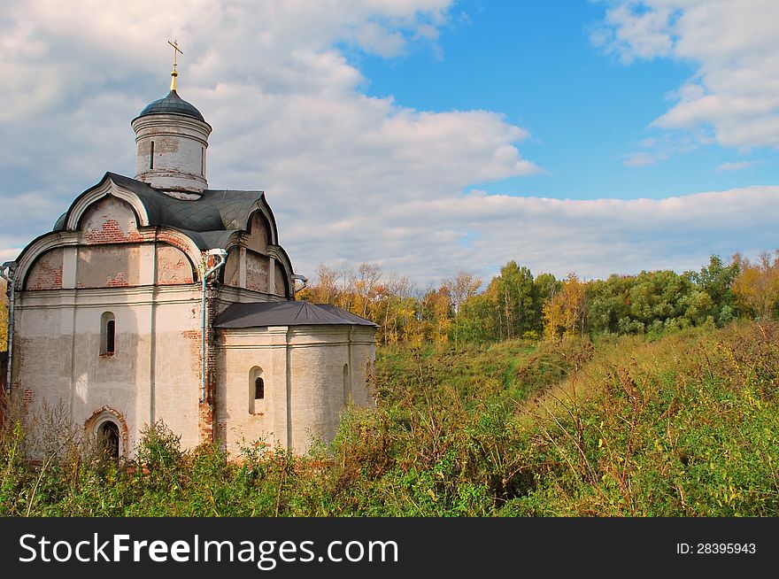 The old church on the background of the autumn forest