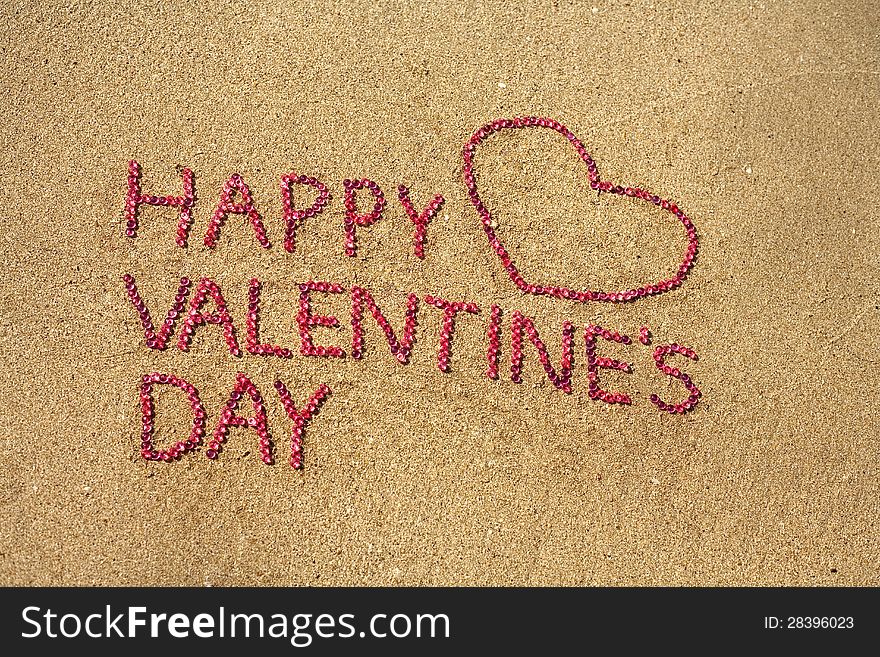 Happy Valentine Day written on sand