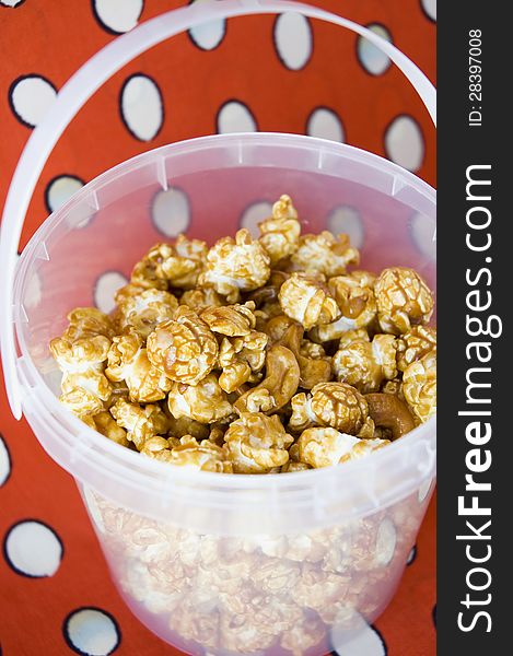 Close up caramel popcorn in bucket with red background