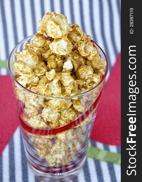 Caramel popcorn in glass with colorful background. Caramel popcorn in glass with colorful background