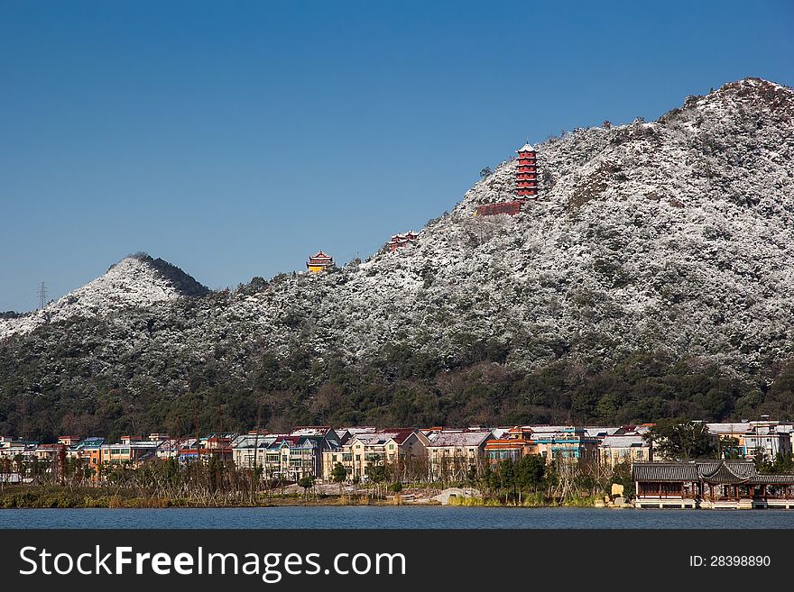 View from Xiang Lake, snow covered hill, village's houses, and color temple in the hill. View from Xiang Lake, snow covered hill, village's houses, and color temple in the hill.