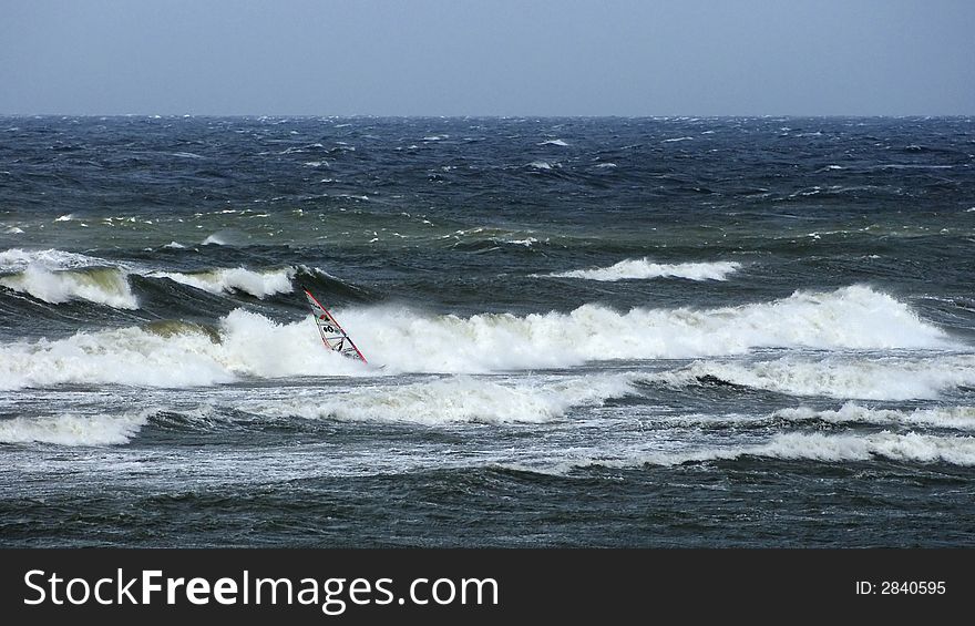 Windsurfer fighting with some waves. Windsurfer fighting with some waves.