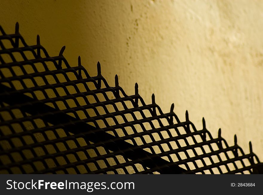 A silhouette of a metal fence