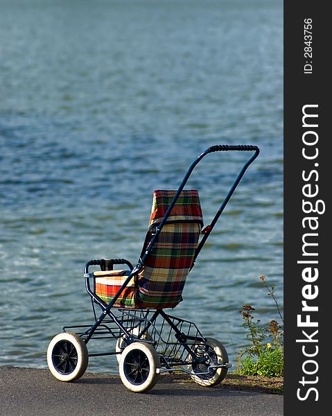 A baby carriage near a lake