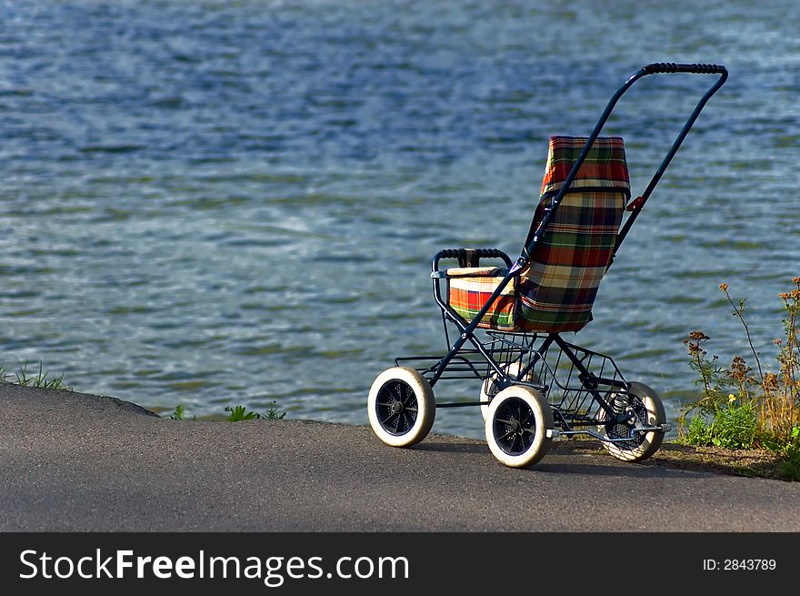 A baby carriage near a lake