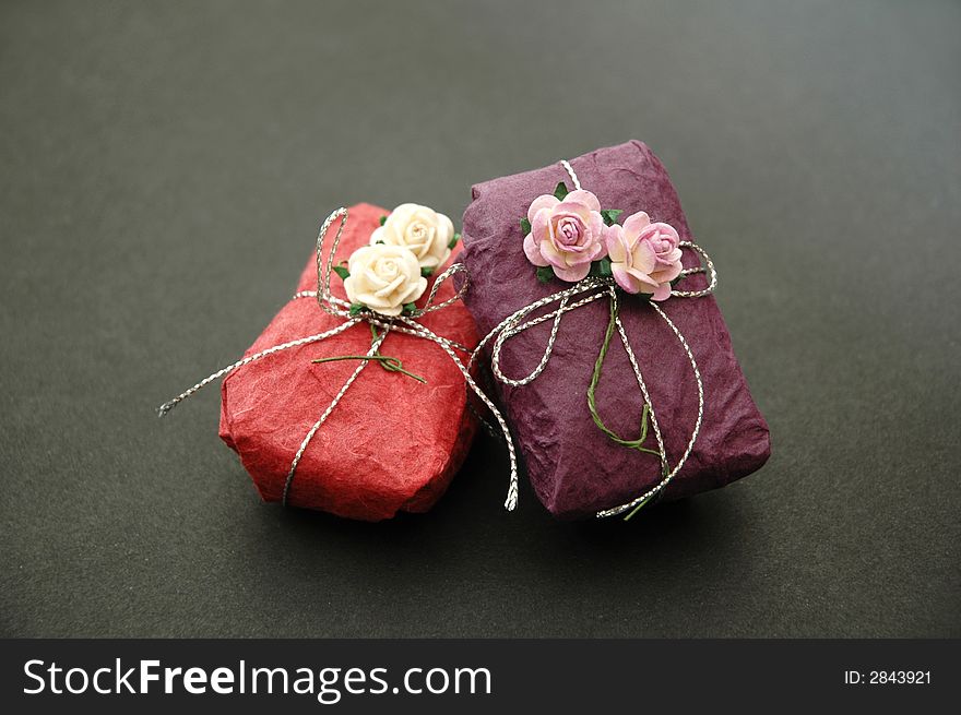Gift wrapped in purple and pink with decorative flowers and silver ribbon. Gift wrapped in purple and pink with decorative flowers and silver ribbon