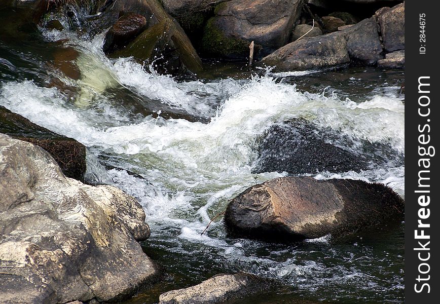 River water splashing over rocks . River water splashing over rocks .