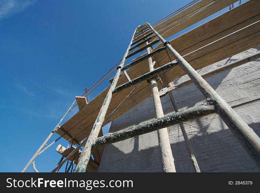 Ladder Leading Up - Exterior Construction Site with Scaffolding & Blue Sky. Ladder Leading Up - Exterior Construction Site with Scaffolding & Blue Sky