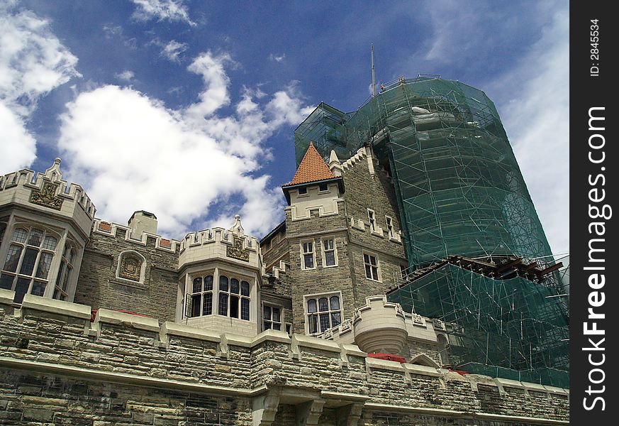 A grand castle is partly covered by scaffold and net while under repair. A grand castle is partly covered by scaffold and net while under repair.