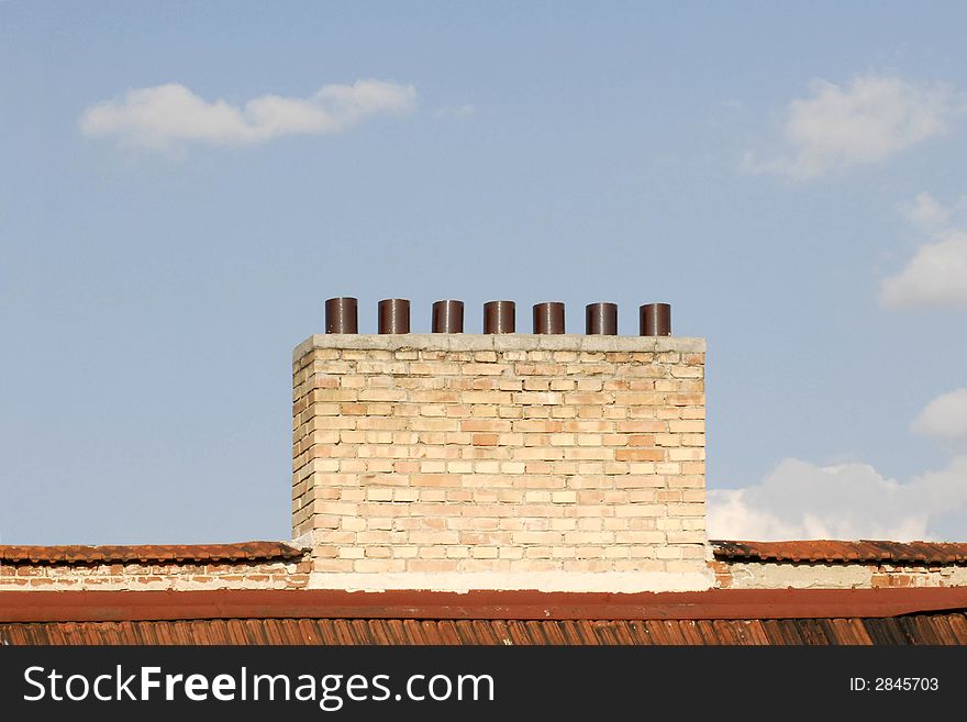 Chimney On Red Roof In Front Of Clear Blue Sky