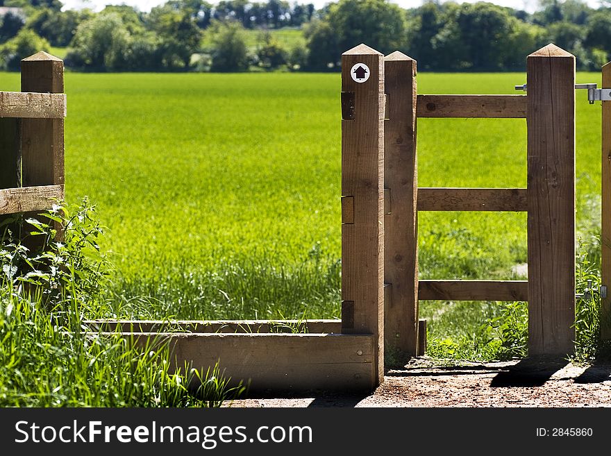 Country gate leading to a green field. Country gate leading to a green field