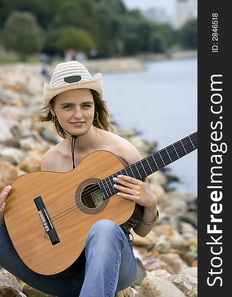 Portrait of the girl with a guitar topless
