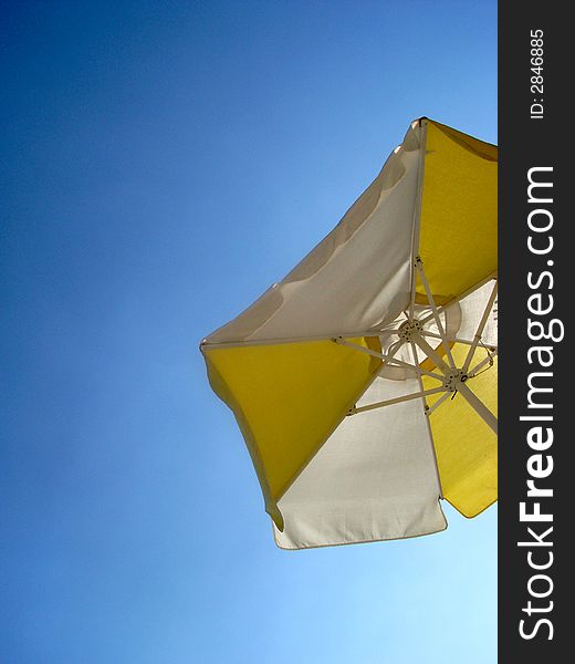 A white sunshade against a deep blue sky.