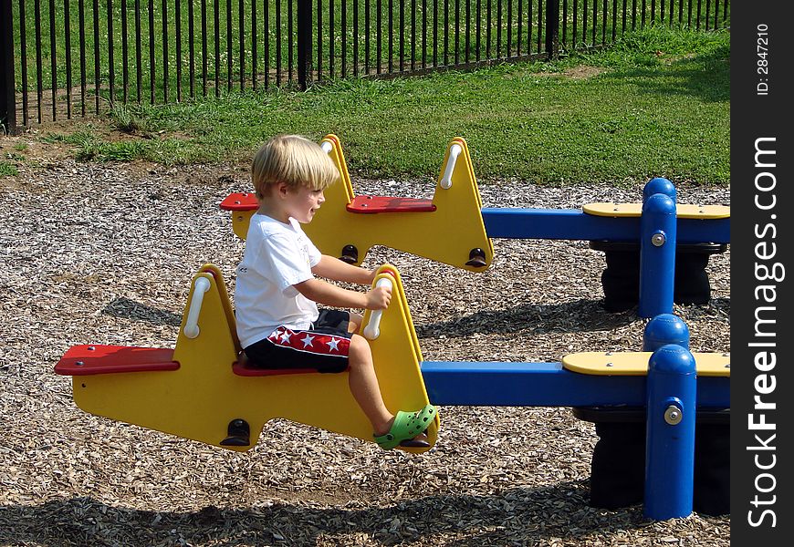 Young boy playing on a seesaw. Young boy playing on a seesaw