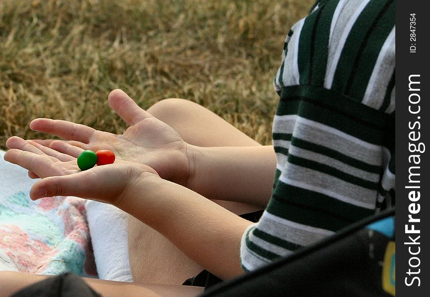 The hands of a youth as he examines the colors his candy has left on his hands. The hands of a youth as he examines the colors his candy has left on his hands.