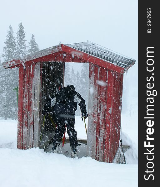 A man ready to start in the starting booth of a downhill competition when the competition is cancelled due to heavy snowfall. A man ready to start in the starting booth of a downhill competition when the competition is cancelled due to heavy snowfall