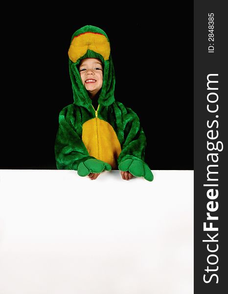 A little girl dressed up in a frog costume holds a blank sign for any message. A little girl dressed up in a frog costume holds a blank sign for any message.