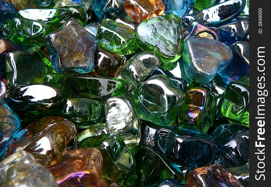 A bin of glass heart and star shapes in various colors. A bin of glass heart and star shapes in various colors.