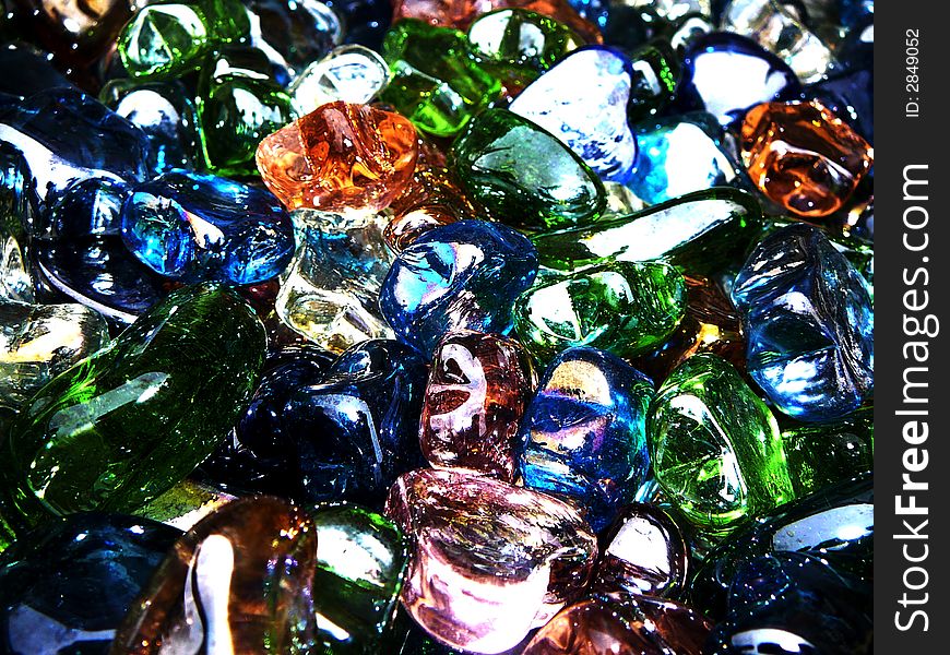 A jubmled bin of glass heart, star and moon shapes in various colors. A jubmled bin of glass heart, star and moon shapes in various colors.