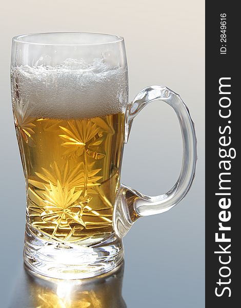 Crystal mug filled by beer with foam. Crystal mug filled by beer with foam.