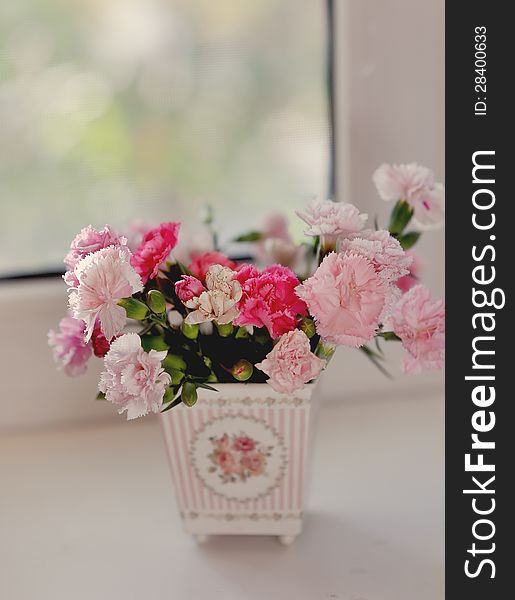 Beautiful fine bouquet of beautiful roses and carnations in a white pot. Beautiful fine bouquet of beautiful roses and carnations in a white pot