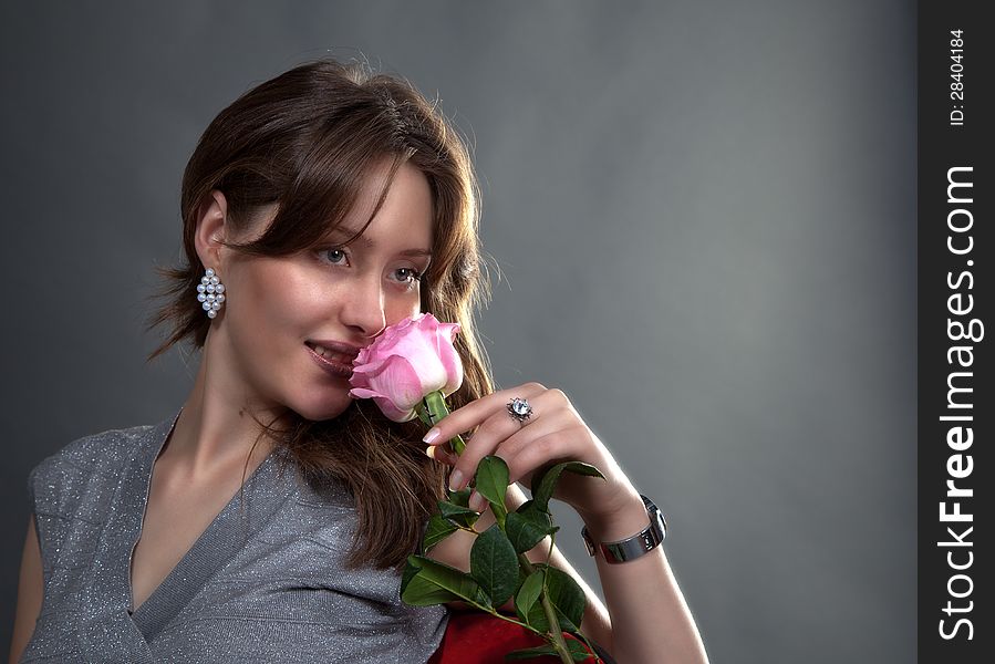 Portrait of lovely girl with pink rose in studio