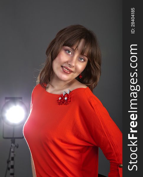 Portrait of pretty girl in red dress in studio