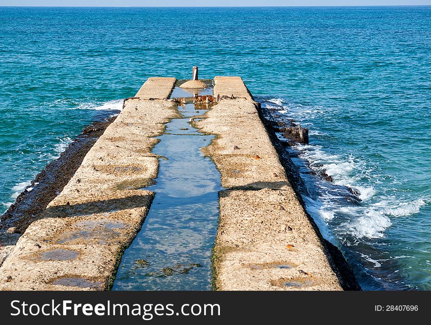 Old concrete pier dock jett into the open ocean sea. Old concrete pier dock jett into the open ocean sea