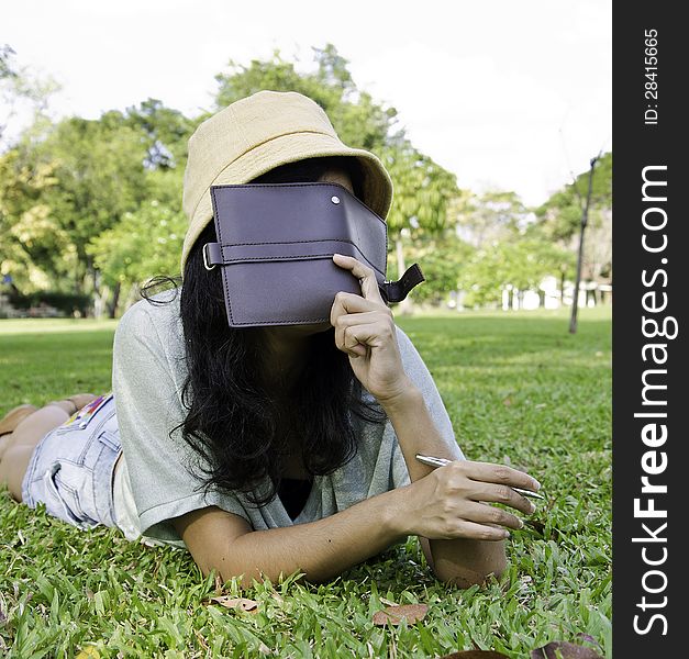 Woman laying on grass and thinking in park, outdoor