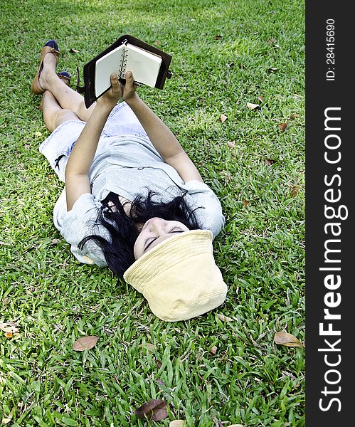 Young Woman Reading A Book In Park