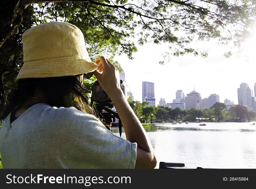 Girl taking photos by professional digital camera in lumpini park , bangkok, thailand