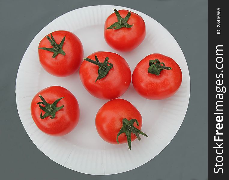 Six Display Red Tomatoes on a White Paper Plate. Six Display Red Tomatoes on a White Paper Plate.