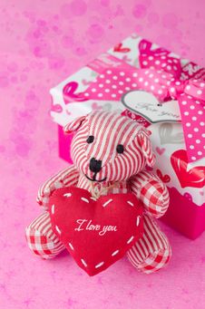 Teddy Bear With A Heart In The Hands Near A Gift Box And Bokeh Royalty Free Stock Photos