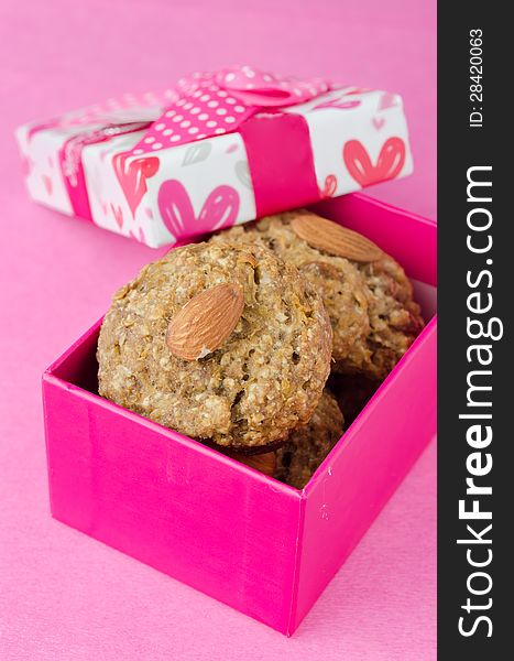 Gift box with homemade oatmeal cookies on a pink background