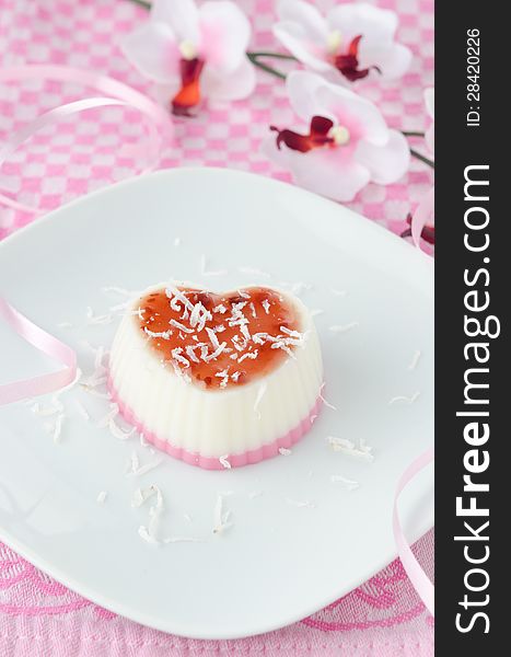 Two-layer dessert with coconut cream in the form of heart on white plate