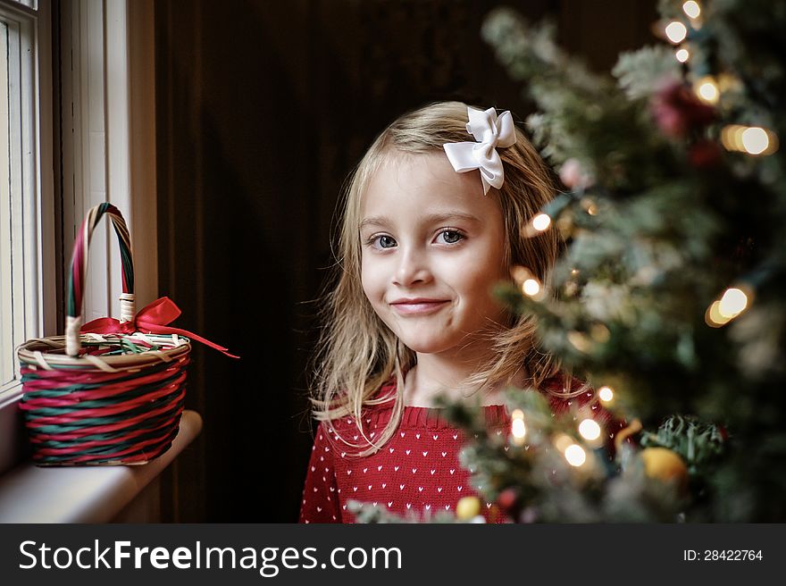 Little Girl Smiling Next to a Christmas Tree. Little Girl Smiling Next to a Christmas Tree