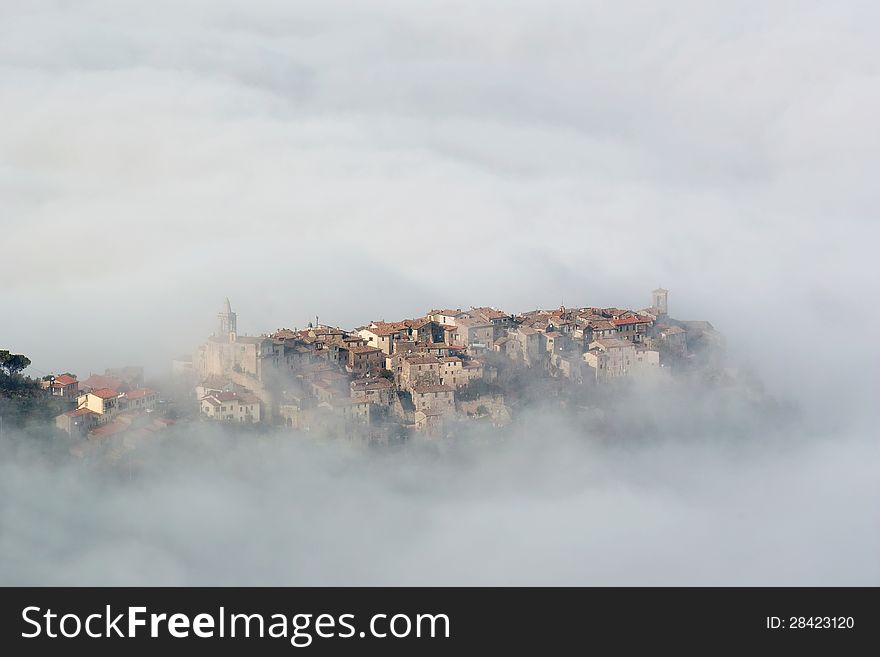 Small medieval village emerges from the fog. Small medieval village emerges from the fog
